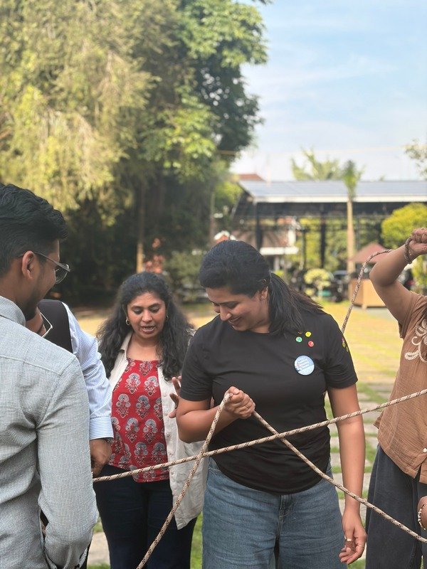 Team members working together on a rope activity